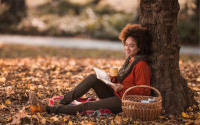 Young woman reading outdoors under a tree