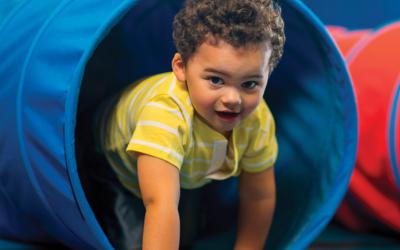 Child crawling out of a play tunnel