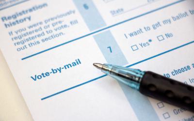 A pen atop an absentee ballot request form
