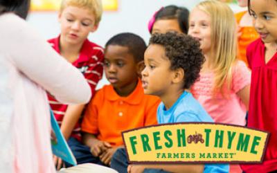Woman reading to a diverse group of children, plus Fresh Thyme logo