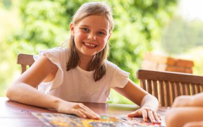 Child at an outdoor table with a puzzle