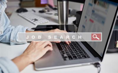 Hands at a laptop behind a search bar that says job search