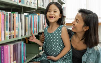 A mother and daughter near shelves of books