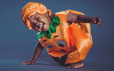 Young child in a pumpkin costume