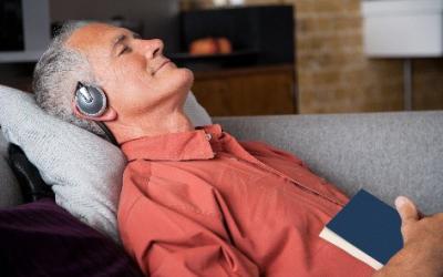 Man lying on couch with eyes closed and headphones on