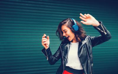 Woman with headphones and music player dancing