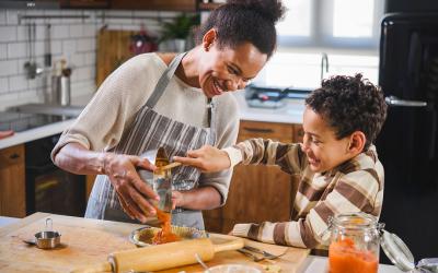 Mother and son in kitchen making pumpkin pie