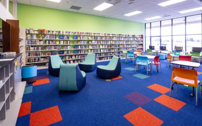 Tables and chairs and bookshelves inside teen area