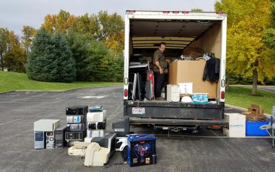 Cargo area of large truck is full of boxes; truck is surrounded by computer equipment