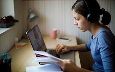 Student working on laptop wearing headphones