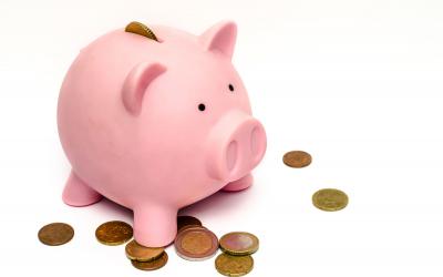 Pink piggybank surrounded by coins