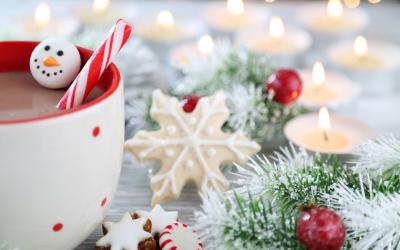 Wintry image of greenery, mug of cocoa and candles