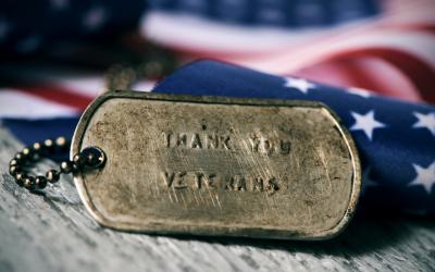 Military dog tags in front of an American flag