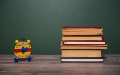 Stack of books on table next to clock