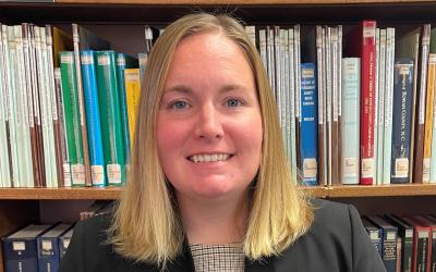 Headshot of Lauren Robinson in front of library bookshelves