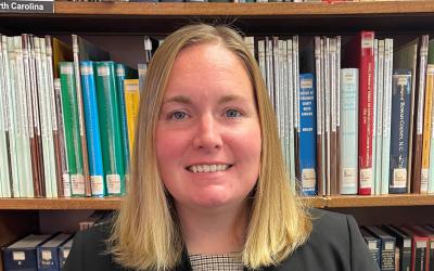 Headshot of Lauren Robinson in front of library bookshelves