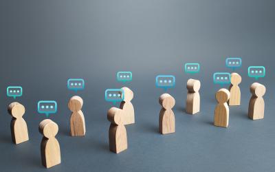 Wooden people figurines with speech bubbles above them