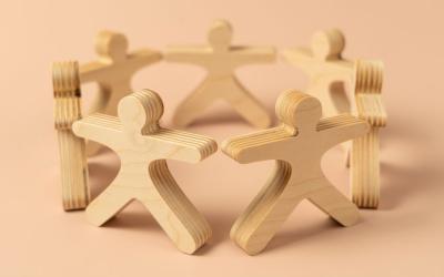 Seven wooden people figures positioned in a circle