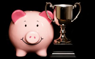 PIggy bank next to a trophy