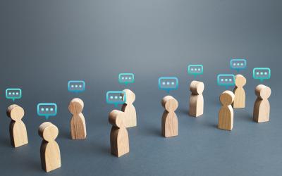 Wooden figurines with speech bubbles over their heads