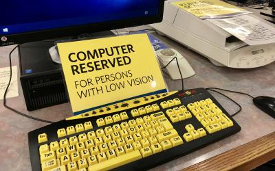 Sign that says: Computer reserved for persons with low vision