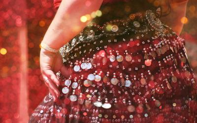 Person in dancing pose wearing beaded skirt