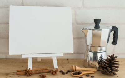 An art easel with a blank canvas and a small moka pot coffee maker