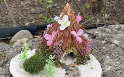 Fairy house covered with pine needles and flower petals