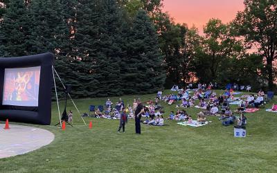 An audience watching a movie outdoors at Northwest Library backyard.