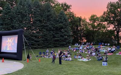 An audience watching a movie outdoors at Northwest Library backyard.