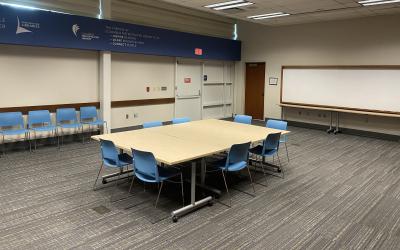 Table and chairts set up in the center of a meeting room
