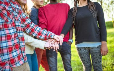 Teens stacking their hands in solidarity