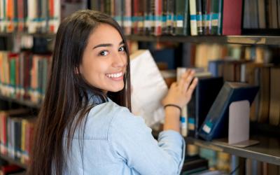 Girl smiling and shelving books