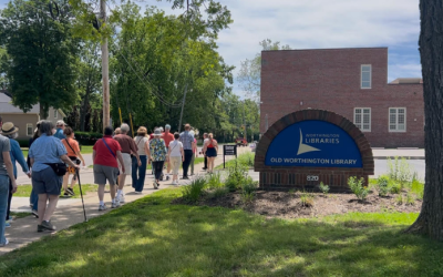 A group of patrons being led during a Worthington Walks program in front of Old Worthington Library