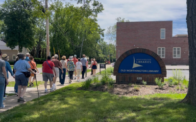 A group of patrons being led during a Worthington Walks program in front of Old Worthington Library