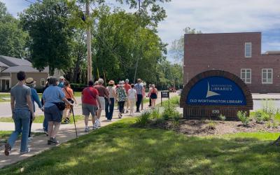 A group of patrons being led during a Worthington Walks program in front of Old Worthington Library