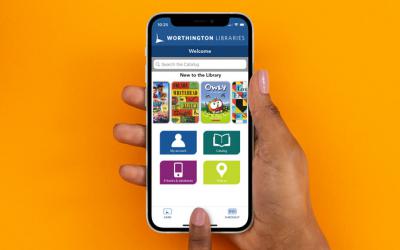 Hand holding smartphone with Worthington Libraries mobile app