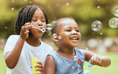 Children blow bubbles outdoors