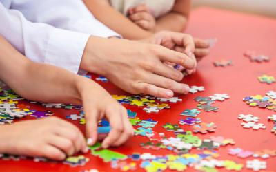 Hands assembling jigsaw puzzle pieces