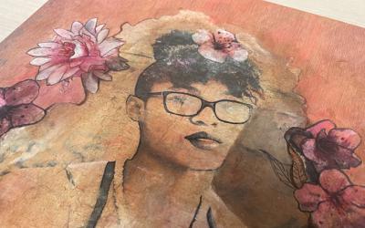 A piece of wood with an artistic, image-transferred portrait and flowers.