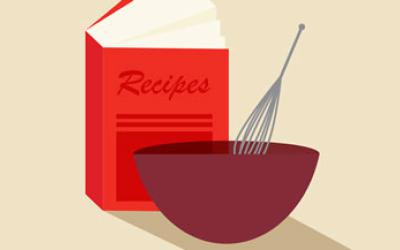 A bowl and whisk next to a cookbook