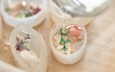 Three resin molds setting with craft supplies inside.