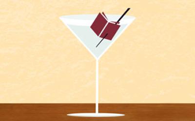 A martini glass with a small book in it on the toothpick.