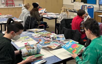 People at a table browsing books, magazines