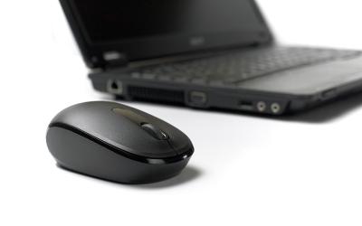 Mouse with scroll wheel in front of laptop