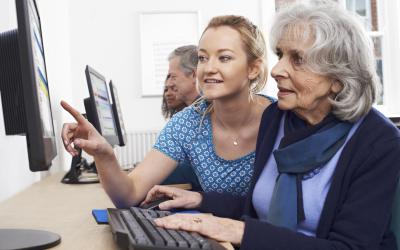 Woman getting computer help from another