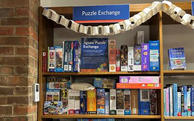 Shelves with puzzle boxes on display and a sign that reads Puzzle Exchange