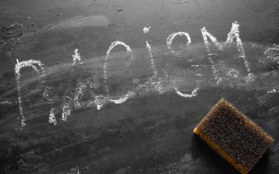 Chalkboard and eraser with the word RACISM erased