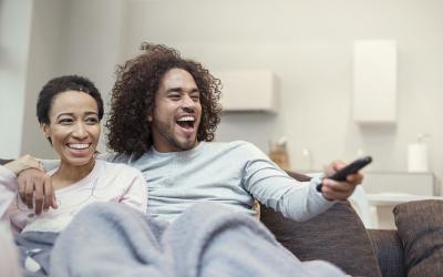 Happy couple watching TV on a couch