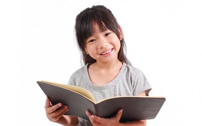 Girl holding a book and smiling